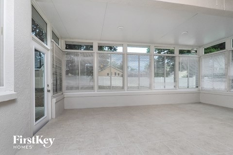 an empty living room with large windows and a balcony