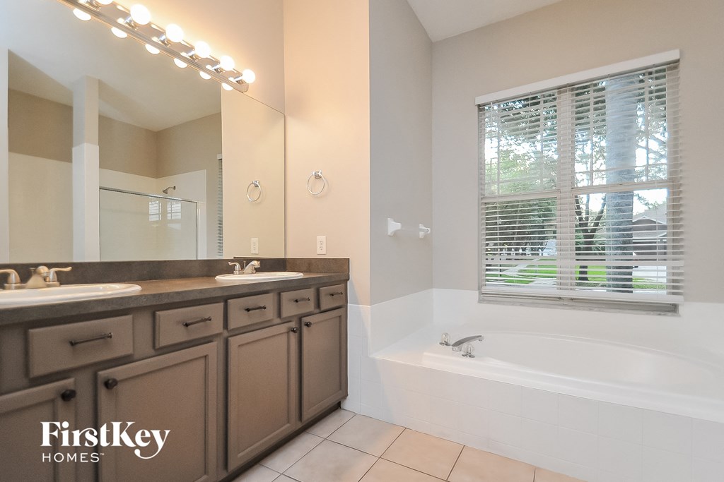 a bathroom with two sinks and a bath tub