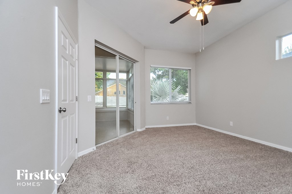 the living room of an empty house with a ceiling fan