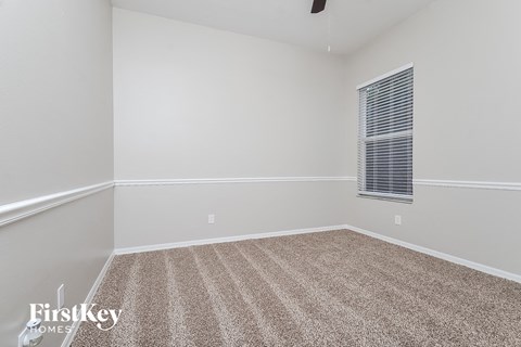 an empty room with carpet and a window