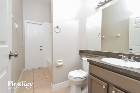 a bathroom with a toilet sink and mirror and a shower