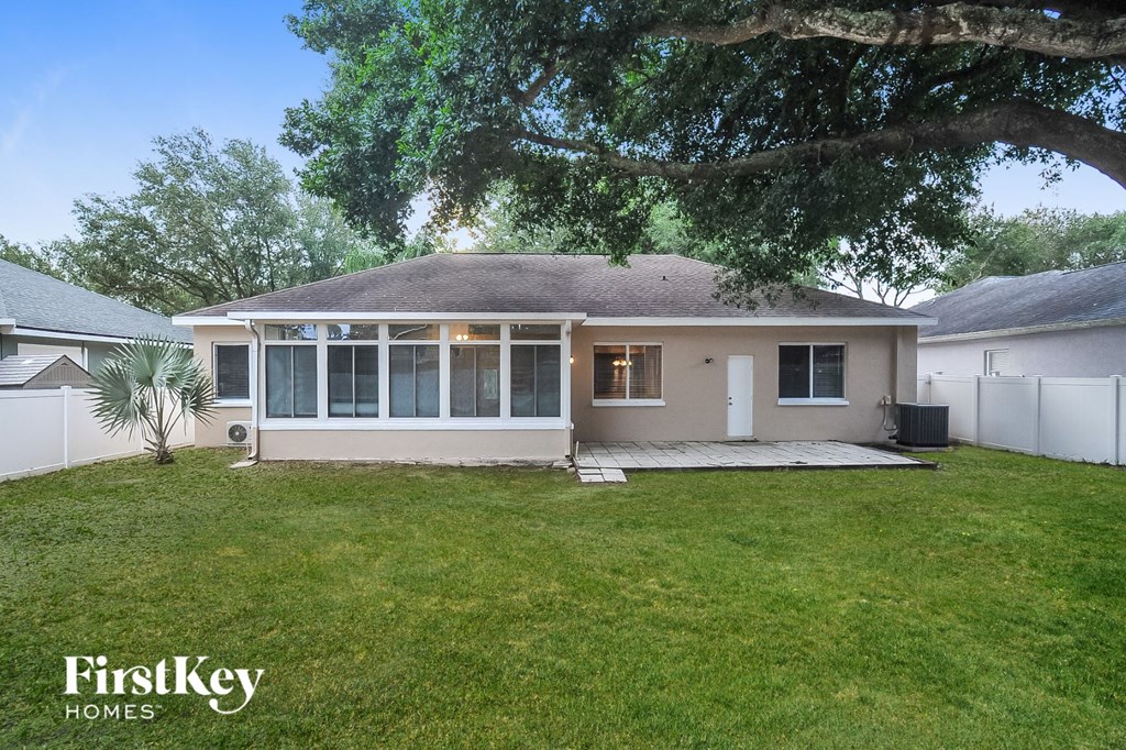 a white house with a yard and a tree