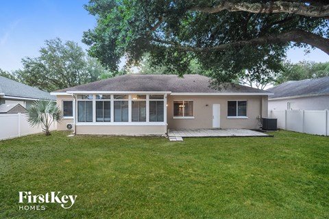 a white house with a yard and a tree