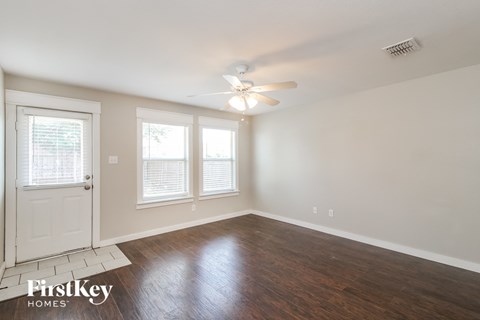A room with a white door and a fan on the ceiling.