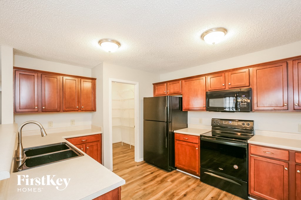 a kitchen with black appliances and wooden cabinets