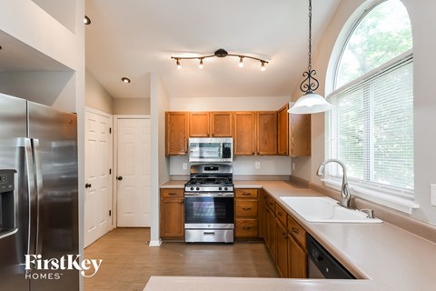 A kitchen with wooden cabinets and a stainless steel refrigerator.