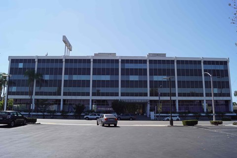 A large building with a parking lot in front.