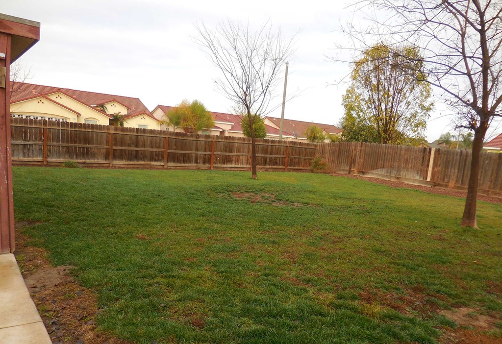 a fenced in backyard with a yard and a fence