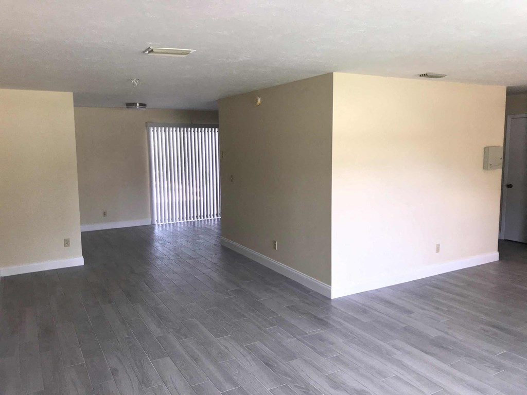 an empty living room with white walls and wood floors