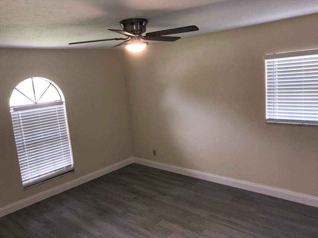 a living room with a ceiling fan and a window