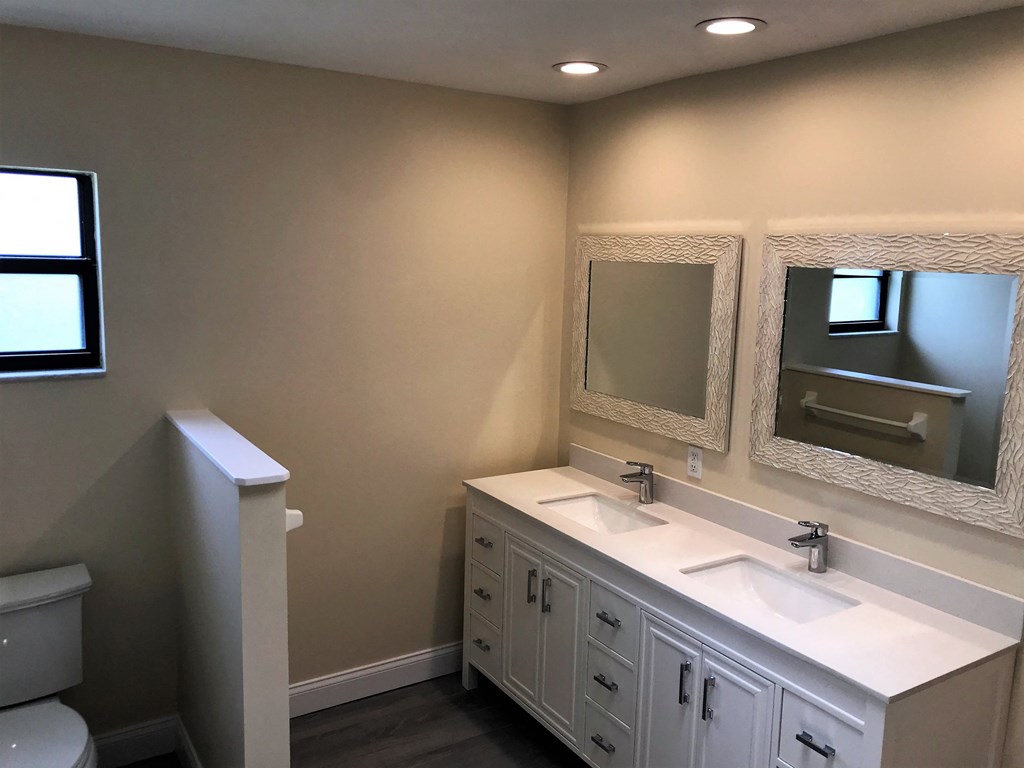 a bathroom with two sinks and two mirrors