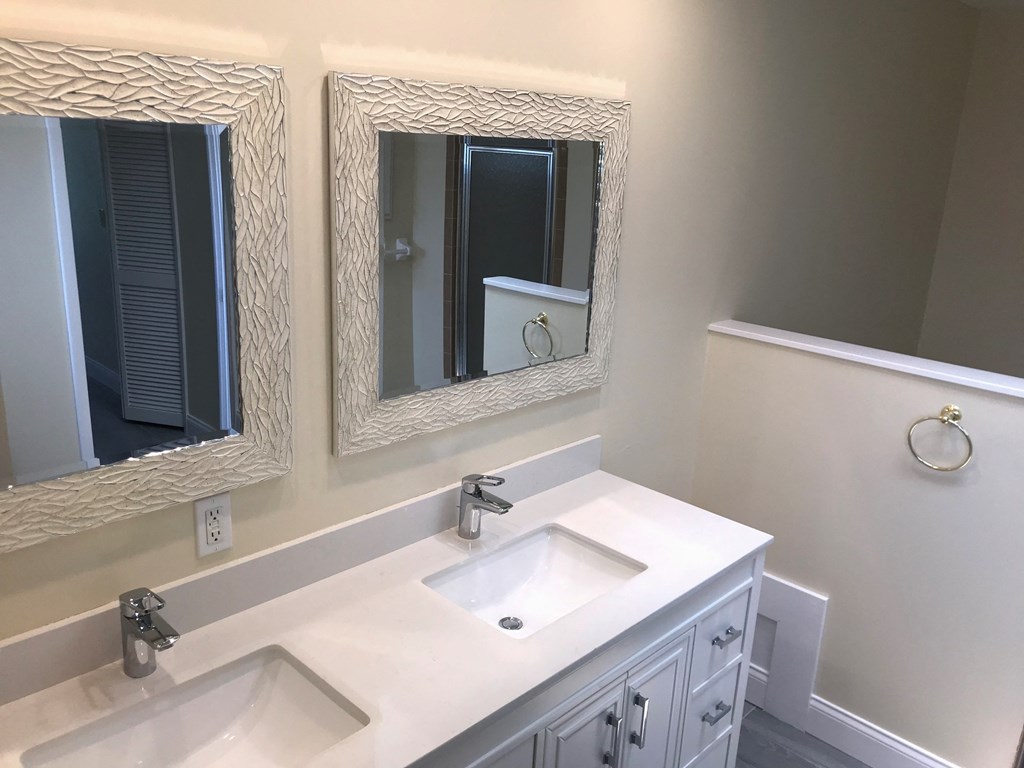 a bathroom with two mirrors and a white sink