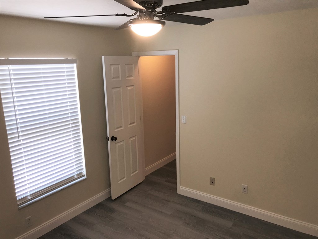 a bedroom with a ceiling fan and a door