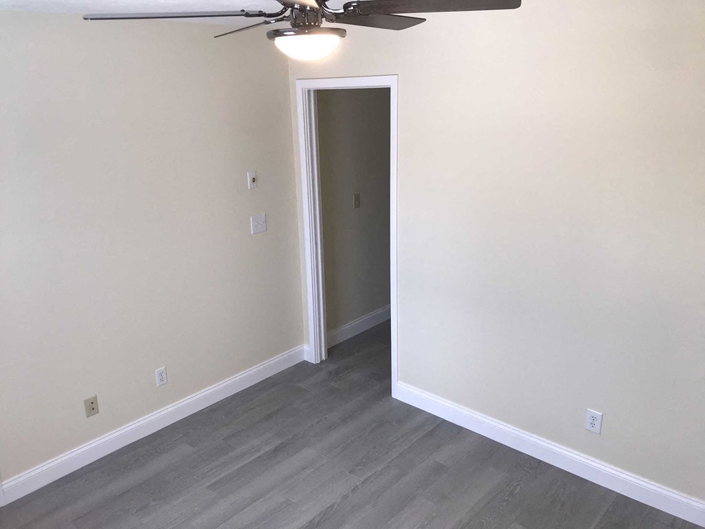 a empty room with a ceiling fan and a door to a closet