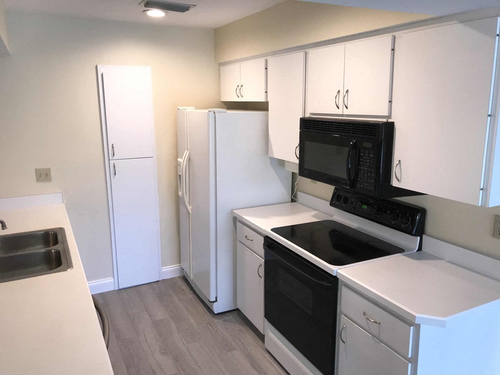 a kitchen with white cabinets and a black stove