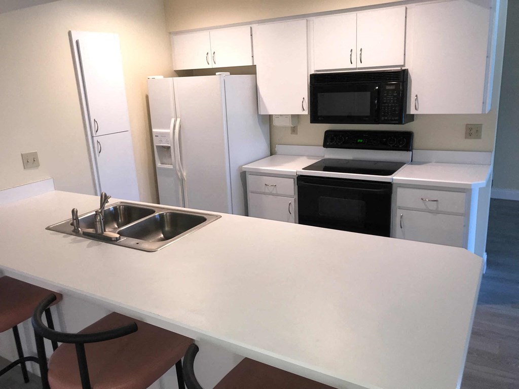 a kitchen with white cabinets and a counter and a sink