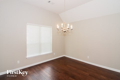 A room with wooden floors and a chandelier.
