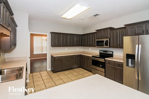 A kitchen with brown cabinets and stainless steel appliances.