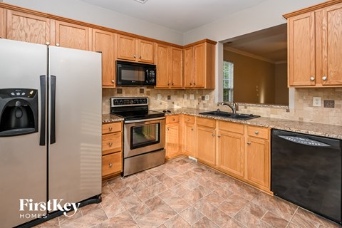 A kitchen with wooden cabinets and a tile floor.