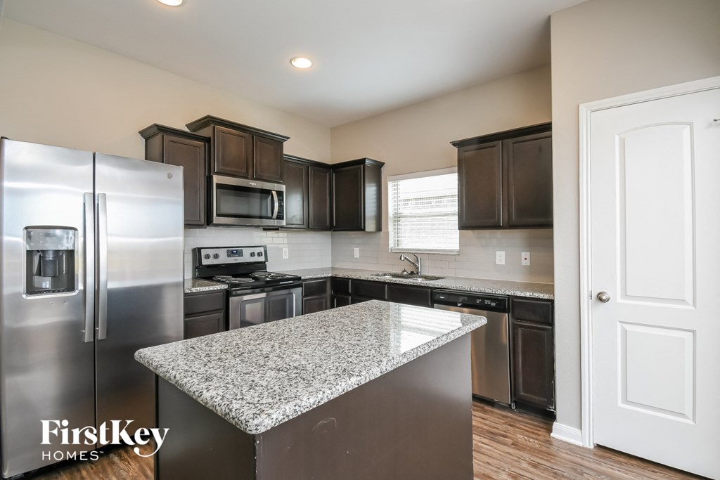 an updated kitchen with granite countertops and stainless steel appliances
