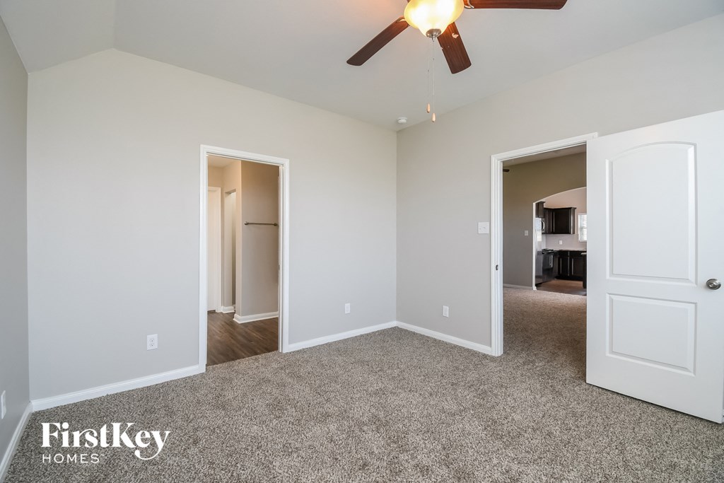 a bedroom with a carpeted floor and a ceiling fan