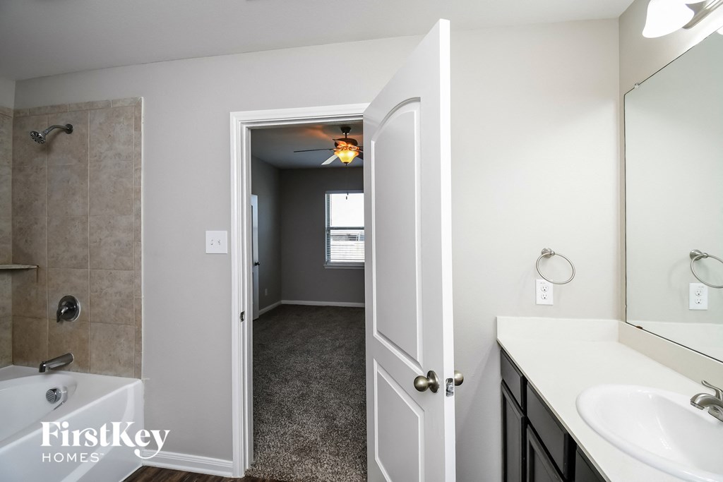a bathroom with a shower and a sink and a mirror