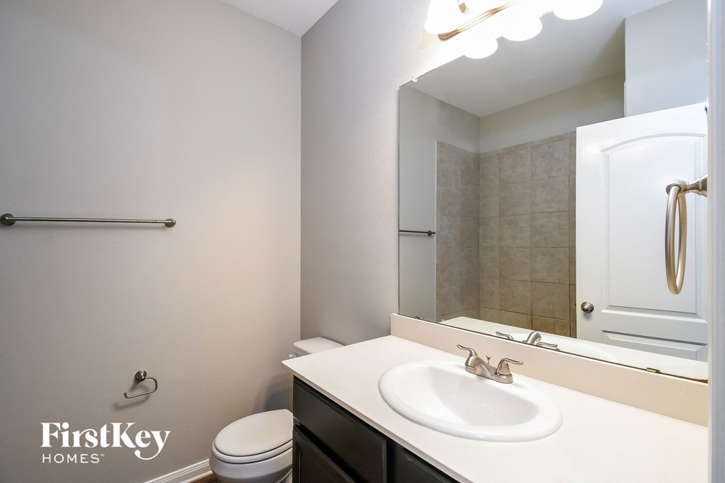 a bathroom with a sink and a mirror and a shower and a toilet