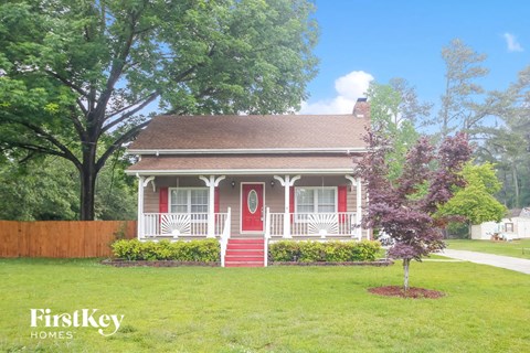 a small red house with a red door and a white porch