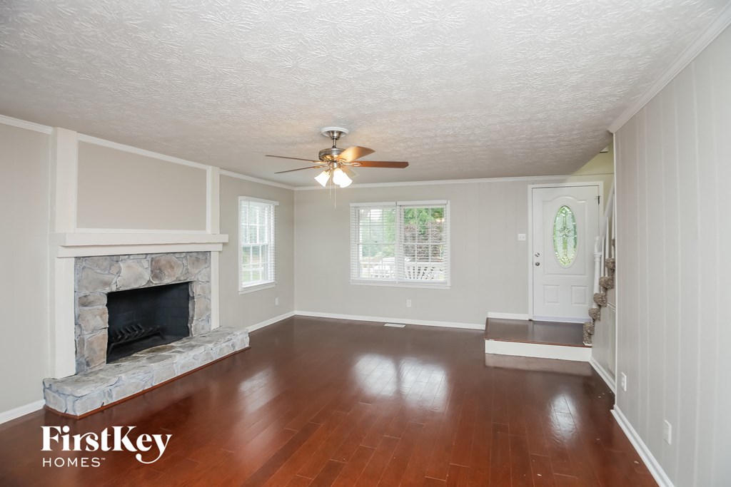 a living room with a fireplace and a ceiling fan