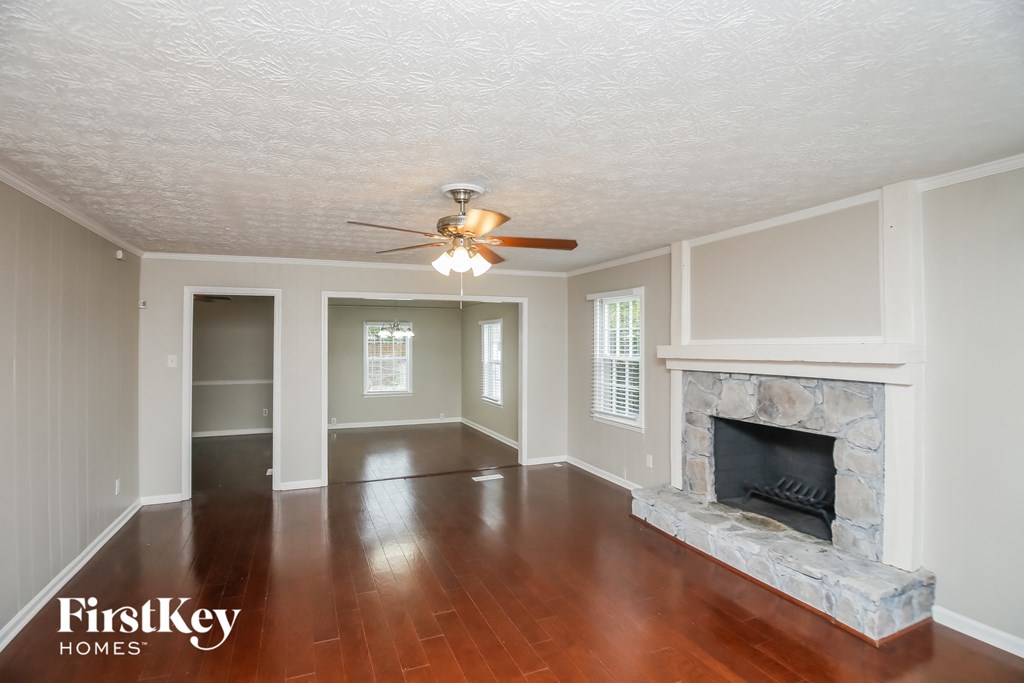 a living room with a fireplace and a ceiling fan