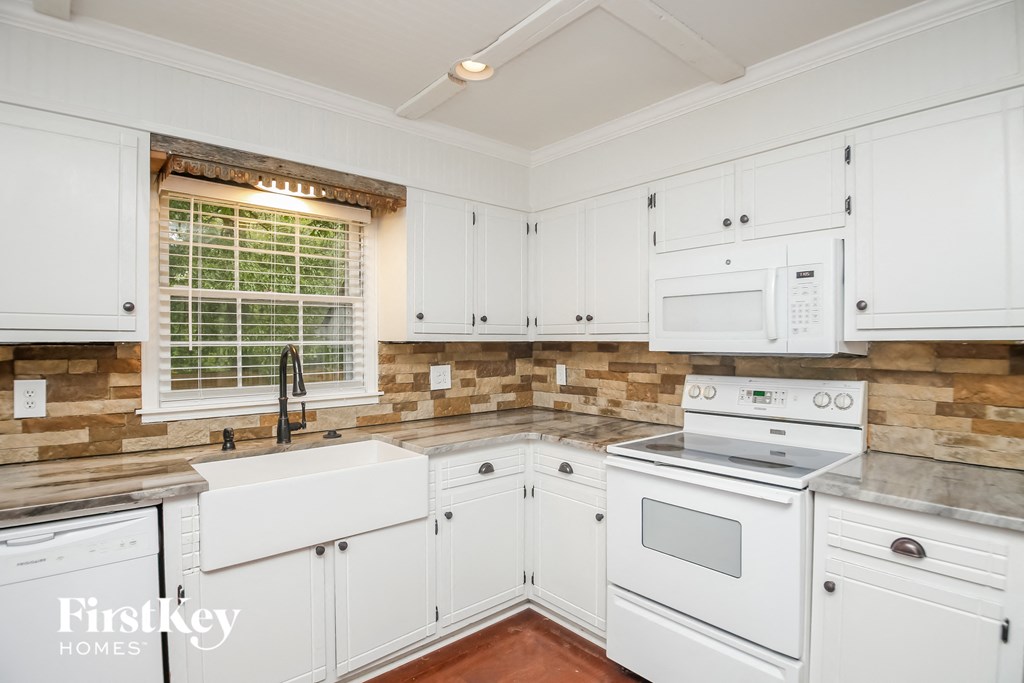 a white kitchen with white appliances and white cabinets