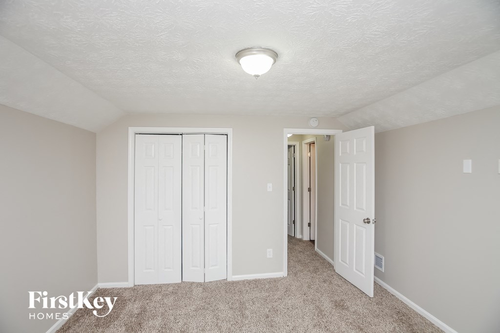 a bedroom with two closets and a door to a hallway