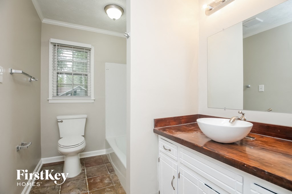 a bathroom with a toilet and a sink and a mirror