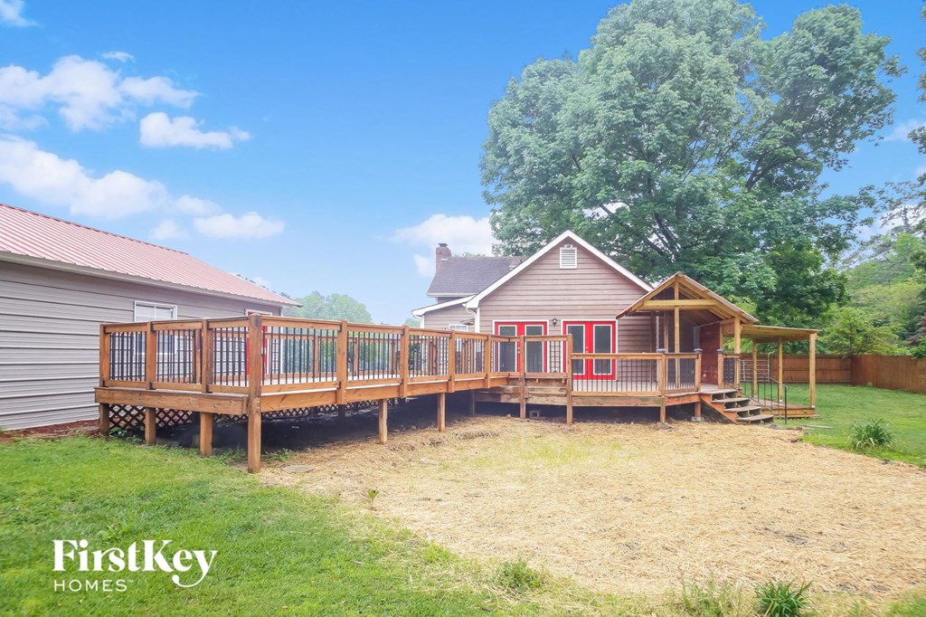 a backyard with a deck and a house with a red door