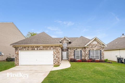 A house with a garage and a driveway in front of it.