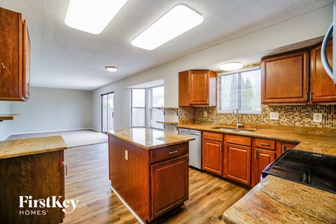 full view of kitchen with wooden cabinets and counter tops and a sink