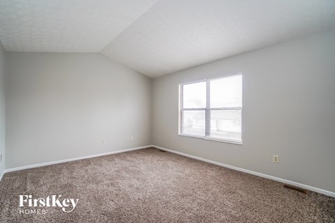a bedroom with carpet and a window