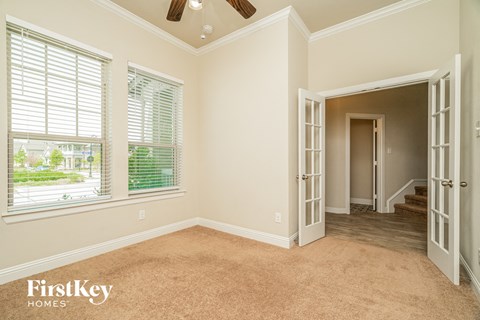 a living room with a large window and a door to a hallway