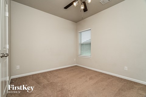 a bedroom with a carpeted floor and a ceiling fan