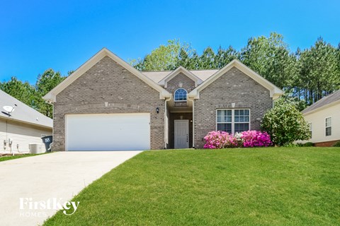 a brick house with a lawn and a white garage door
