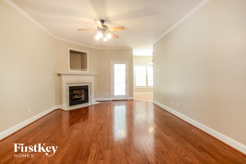 a living room with a fireplace and a ceiling fan