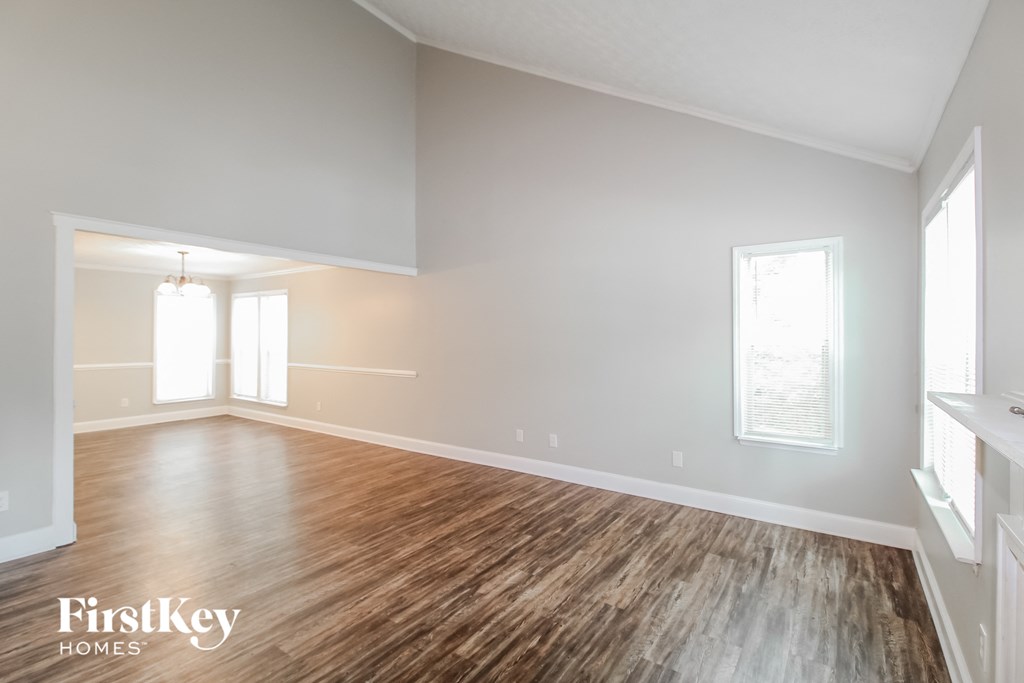 an empty living room with wood floors and white walls