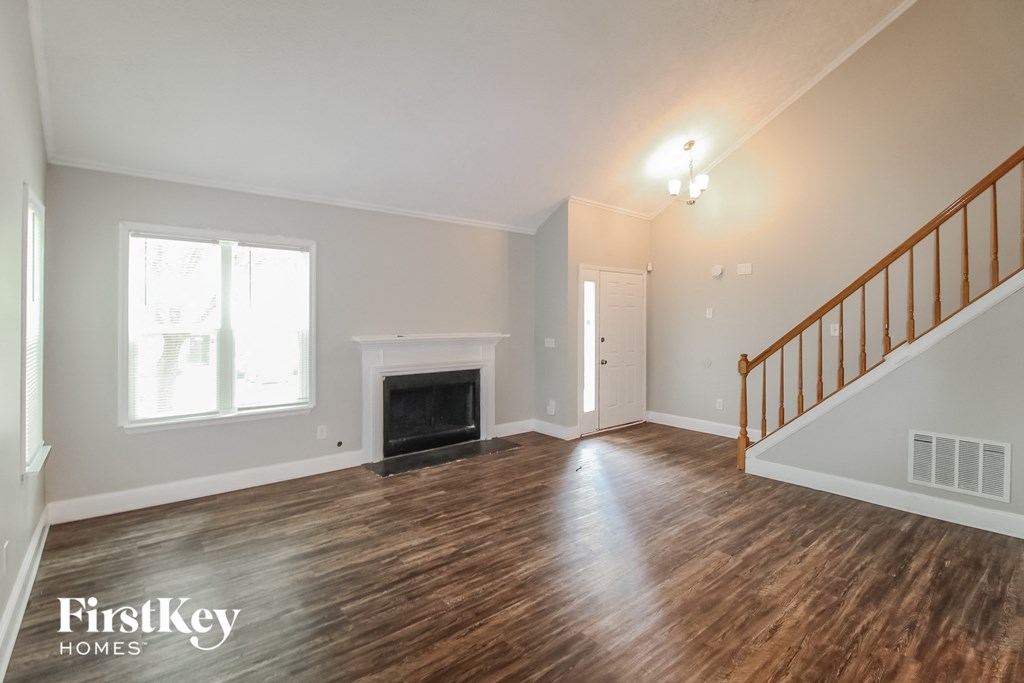 the living room of a house with a staircase and a fireplace