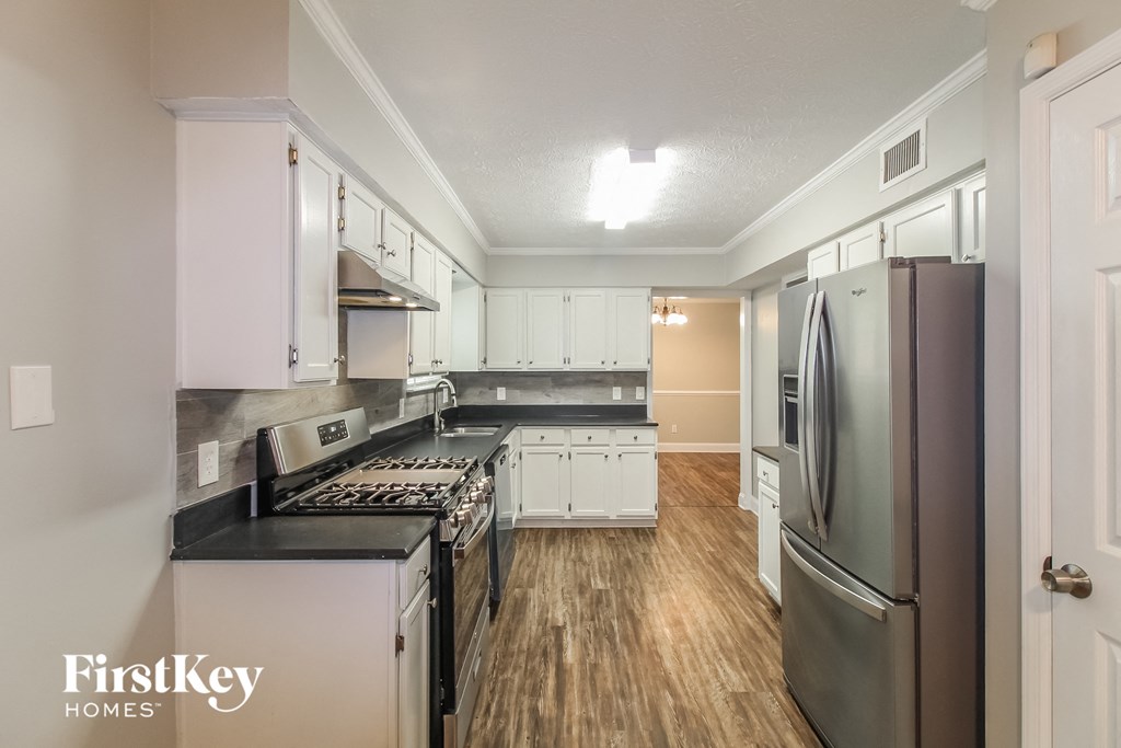 a kitchen with stainless steel appliances and white cabinets