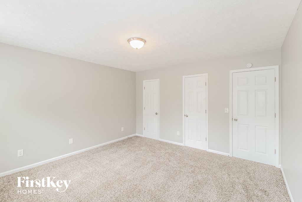 a bedroom with two doors and a carpeted floor
