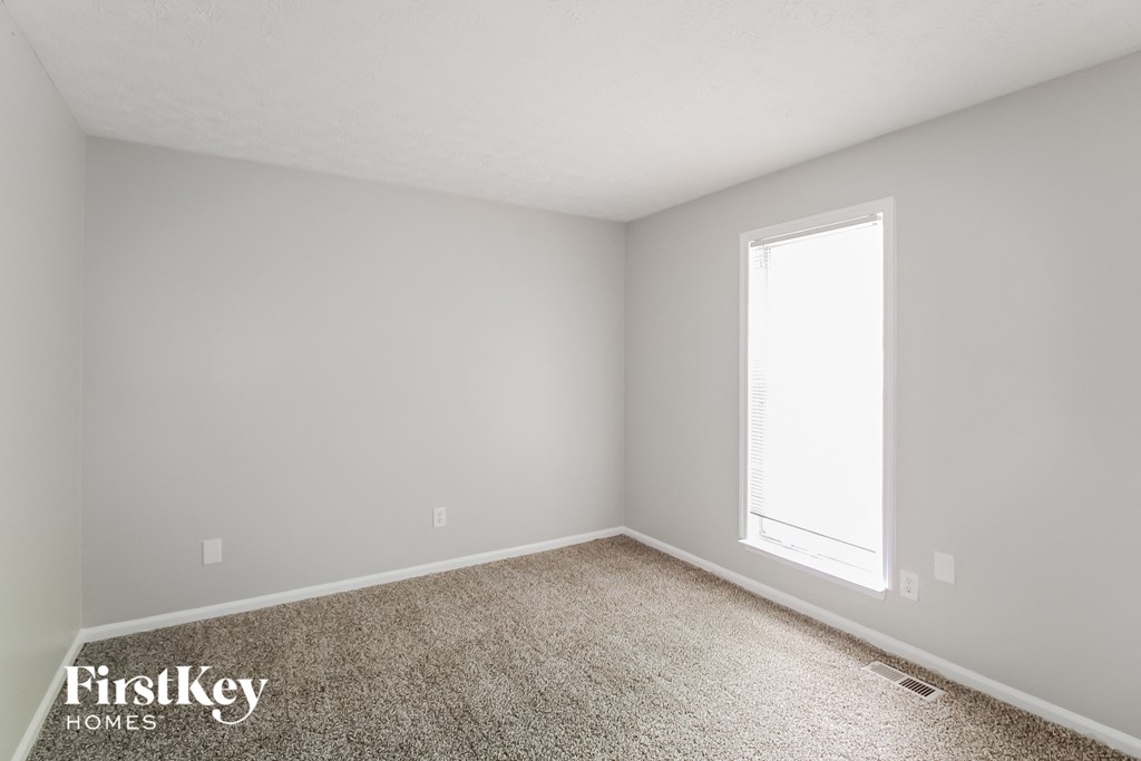 an empty room with carpet and a window