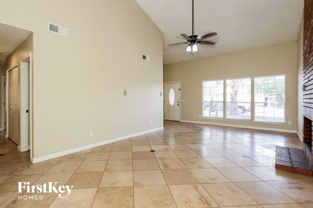 A spacious room with a fan and tile flooring.