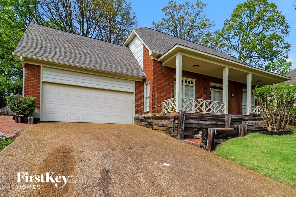A brick house with a white garage door and a porch.