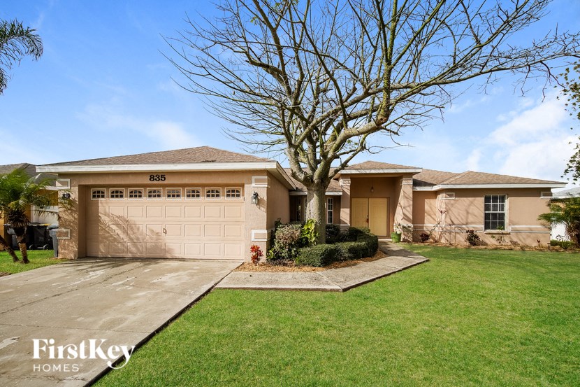 a house with a garage and a tree in the yard