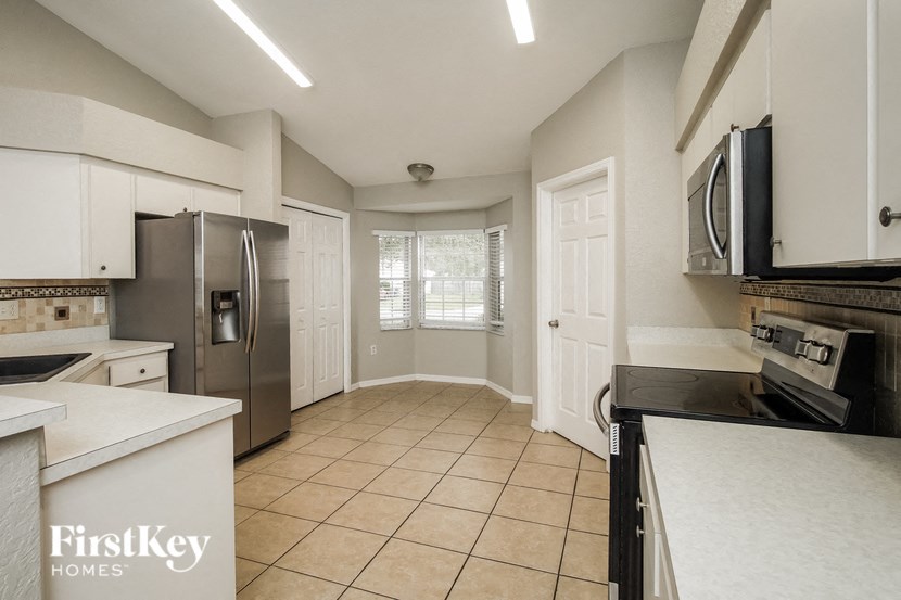 a kitchen with white cabinets and stainless steel appliances